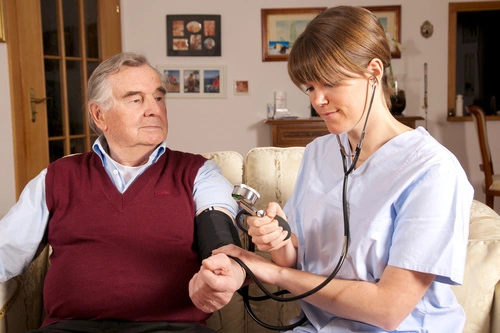 Krankenschwester misst Blutdruck bei Senior