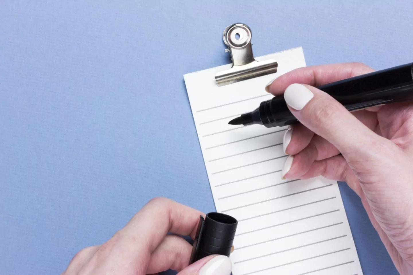 Important business checklist, planning for shopping reminder or project priority task list on blue background with copy space. Marker in female hands