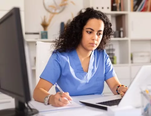 Female doctor working on laptop in office