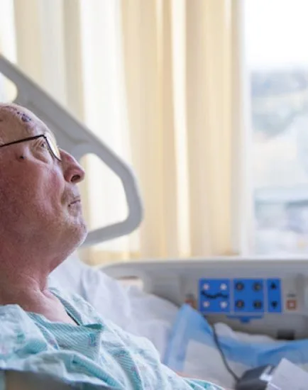 Old man in hospital bed looking up