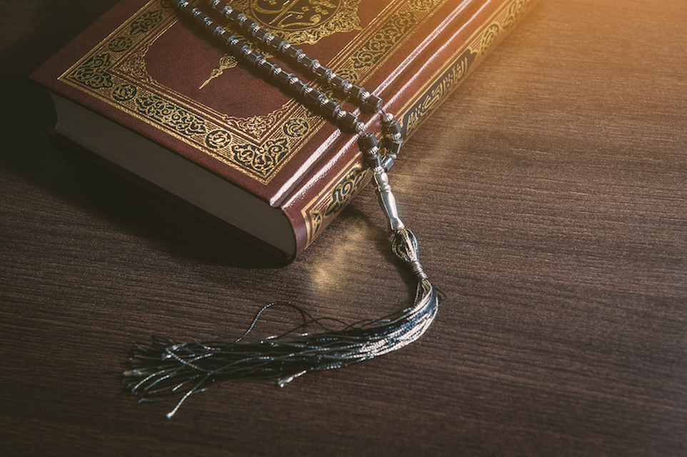 Islam holy book of Muslims, the Quran, holy book on a wooden black background.