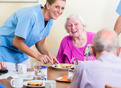 Group of seniors having food in nursing home