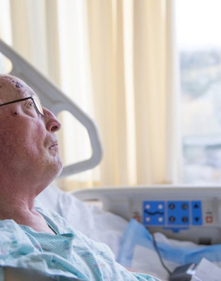 Old man in hospital bed looking up