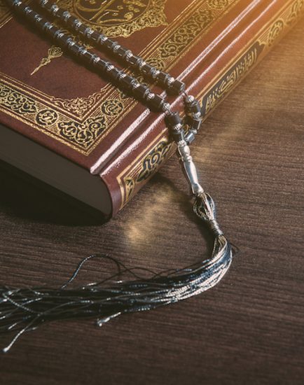 Islam holy book of Muslims, the Quran, holy book on a wooden black background.