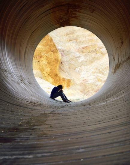 depressed young man sitting in the drain