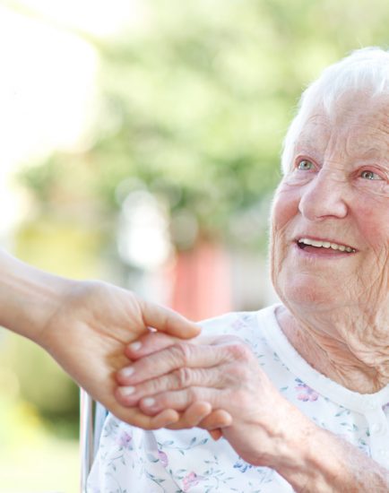 Senior woman holding hands with caretaker