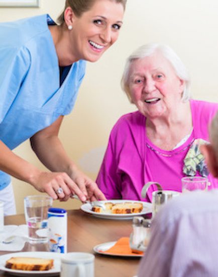 Group of seniors having food in nursing home